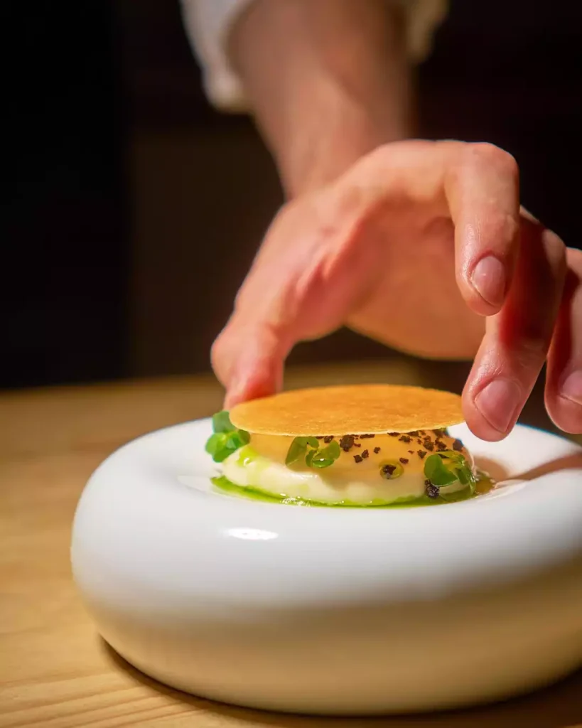une mise en bouche composé d'un siphon pissaladière, d'une glace à l'oignon et de poudre d'olive