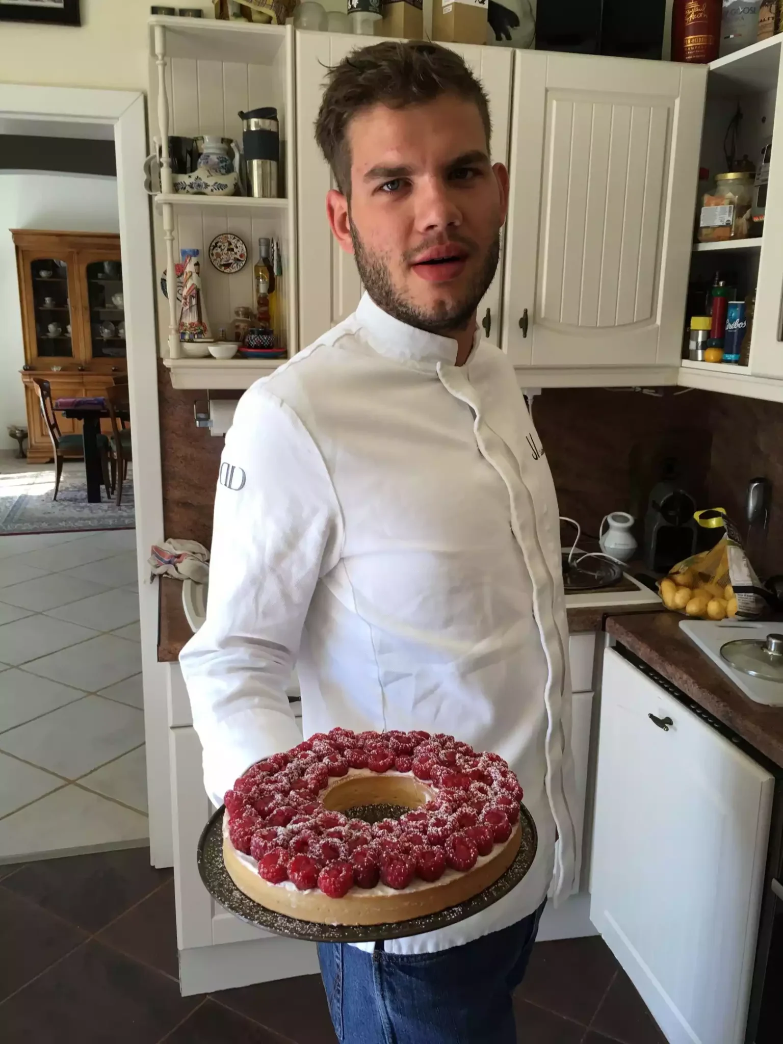 portrait en cuisine avec une tarte aux framboises à la main du chef à domicile Kajetan Kaczmarek