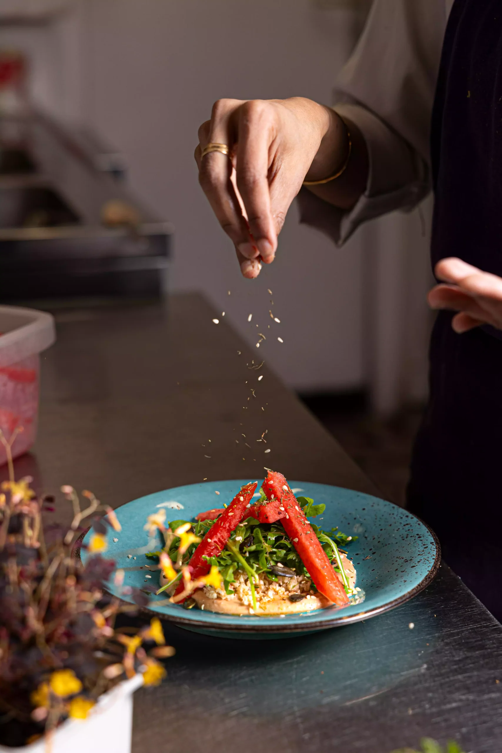Chef Savale Arpitha finishing the plating of a vegetarian dish