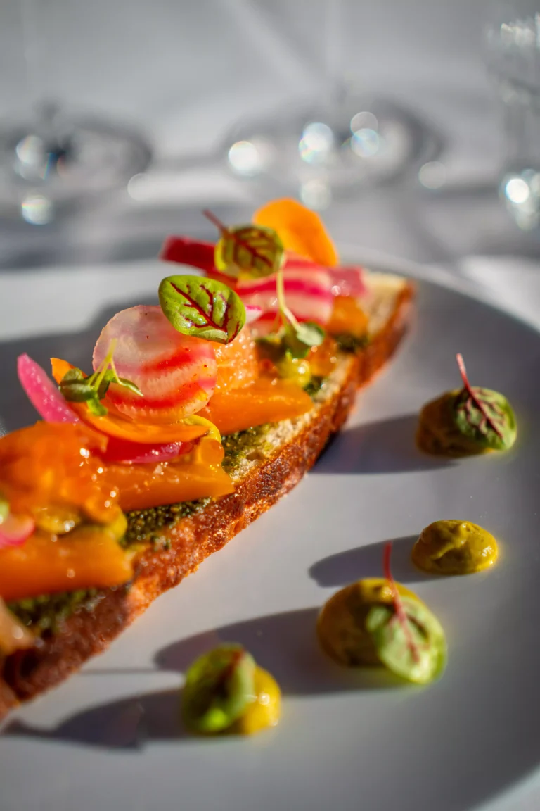 Tartine de légumes croquants et betterave chioggia dressée sur une table de fête