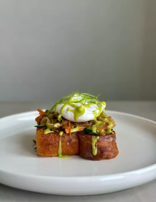 plat représentant une brioche avec des légumes et un oeuf poché sur le dessus