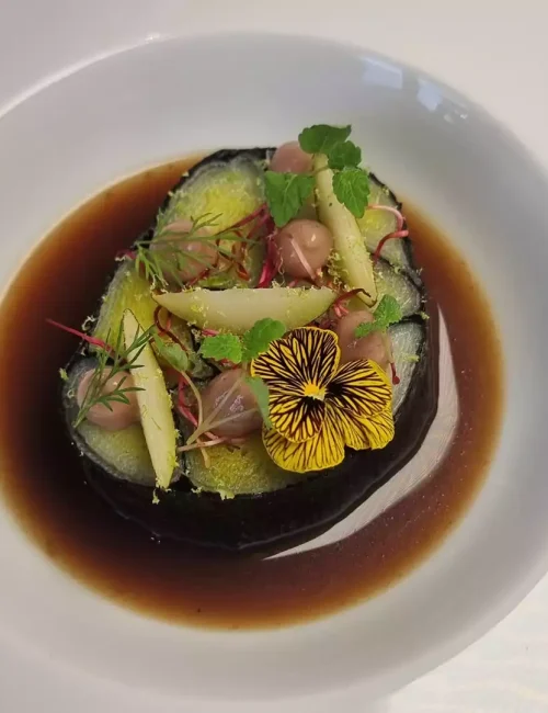 mosaique de poireau avec de l'algue nori et un bouillon confectionné par le chef johann schopff